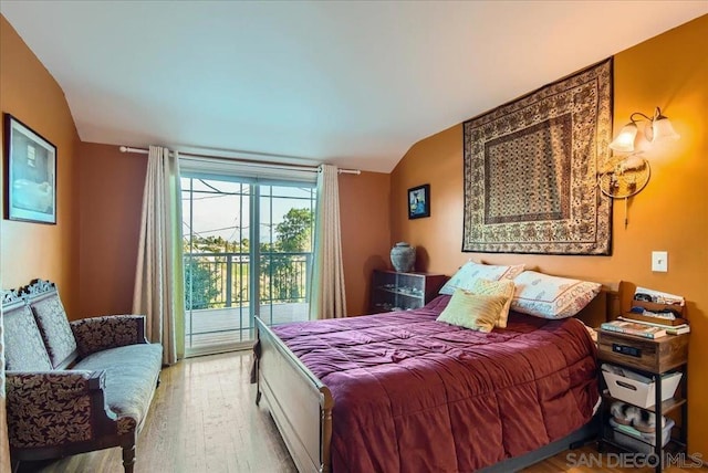 bedroom featuring lofted ceiling, light hardwood / wood-style flooring, and access to outside