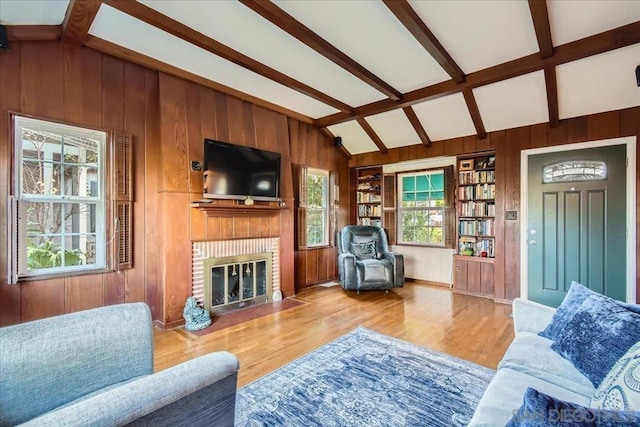 living room featuring vaulted ceiling with beams, wooden walls, and hardwood / wood-style floors