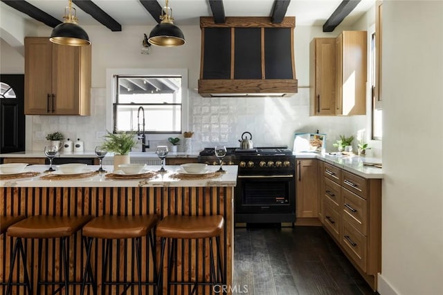 kitchen featuring beam ceiling, range with gas stovetop, hanging light fixtures, and decorative backsplash