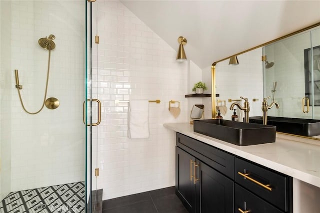 bathroom featuring lofted ceiling, tile walls, vanity, a shower with door, and tile patterned flooring