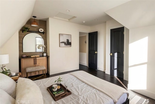 bedroom with vaulted ceiling and dark wood-type flooring