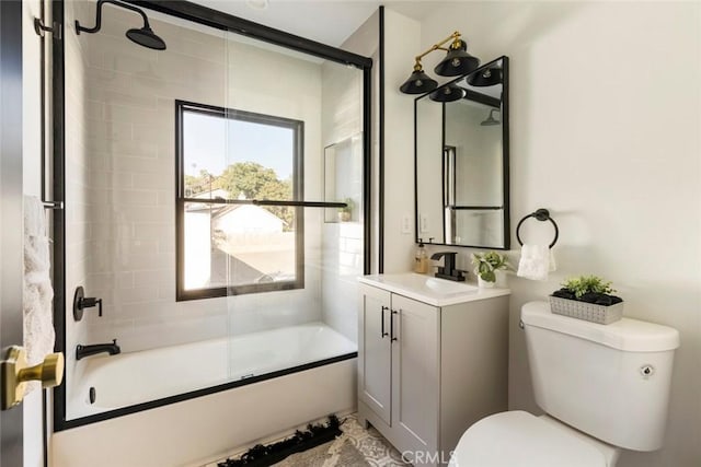 full bathroom featuring bath / shower combo with glass door, vanity, and toilet