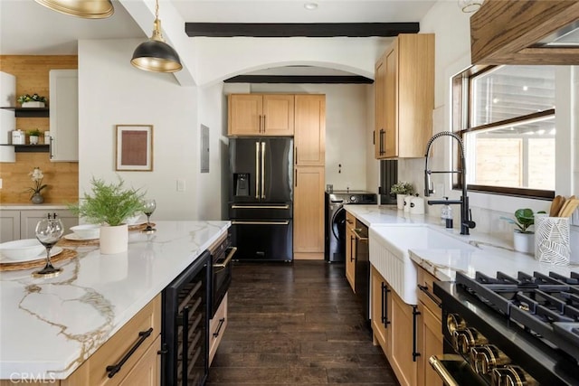 kitchen featuring high end fridge, decorative light fixtures, light stone countertops, and beverage cooler