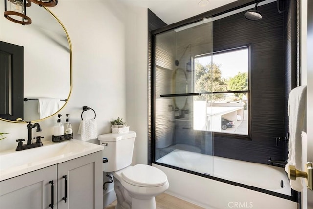 full bathroom featuring vanity, toilet, and combined bath / shower with glass door