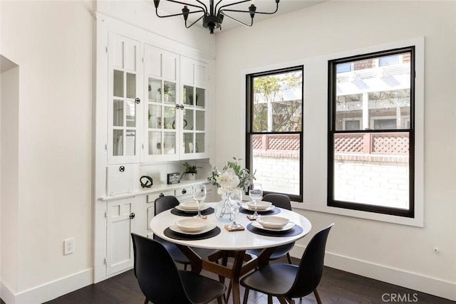 dining space with a notable chandelier and dark hardwood / wood-style flooring