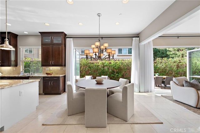 tiled dining room with sink and an inviting chandelier