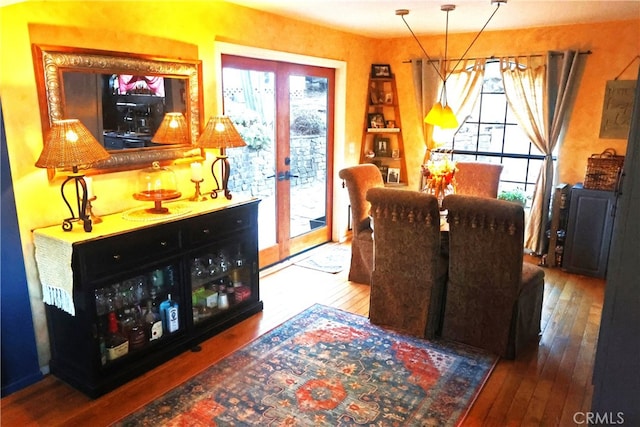 dining space with a healthy amount of sunlight, hardwood / wood-style floors, and french doors