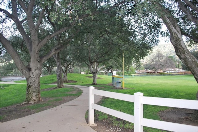 view of property's community featuring a yard and fence