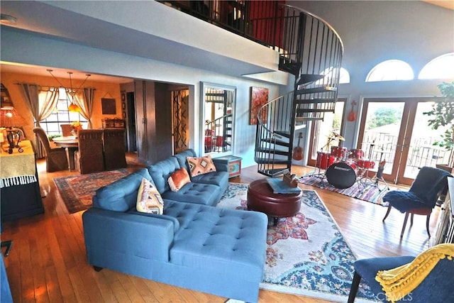 living room with hardwood / wood-style flooring, a towering ceiling, and french doors