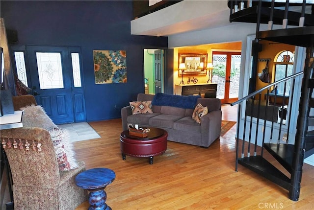 living room featuring stairway, french doors, and wood finished floors