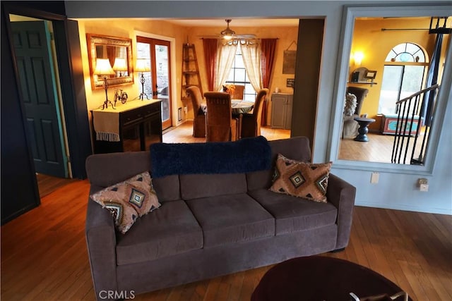 living room with baseboards, a ceiling fan, and hardwood / wood-style flooring