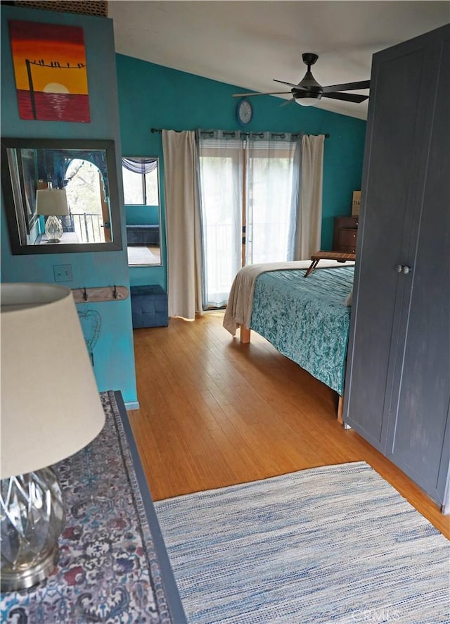 bedroom featuring a ceiling fan, lofted ceiling, and wood finished floors