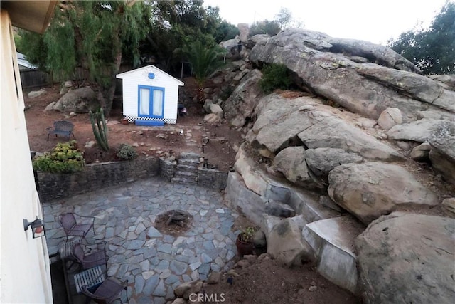 view of yard featuring an outbuilding, a shed, and a patio