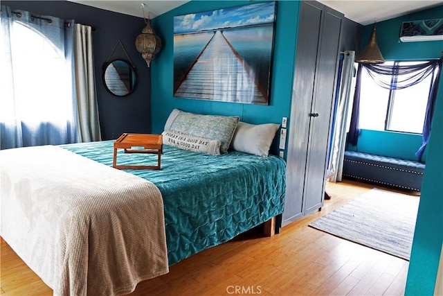 bedroom with lofted ceiling and wood finished floors