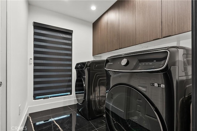 laundry room featuring cabinets and washing machine and clothes dryer