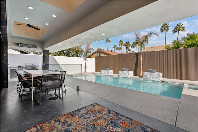 view of pool featuring a patio, an outdoor kitchen, area for grilling, pool water feature, and ceiling fan