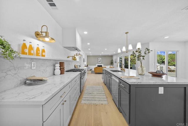 kitchen with sink, gray cabinetry, decorative light fixtures, appliances with stainless steel finishes, and light stone countertops