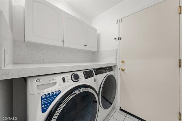 clothes washing area featuring cabinets, light tile patterned floors, and independent washer and dryer