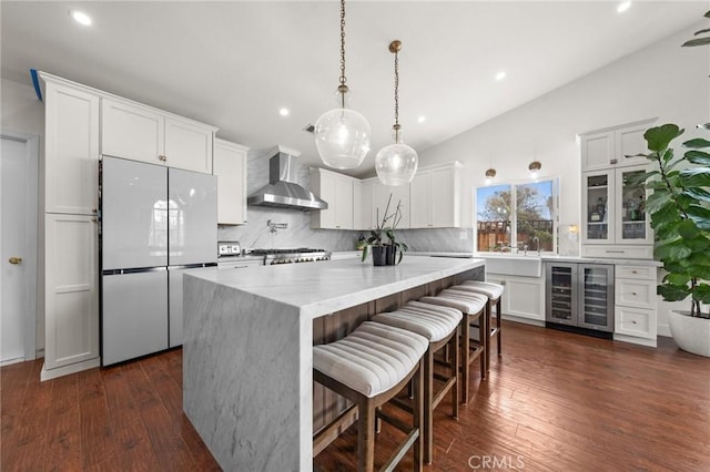 kitchen with white cabinets, wall chimney exhaust hood, and white fridge