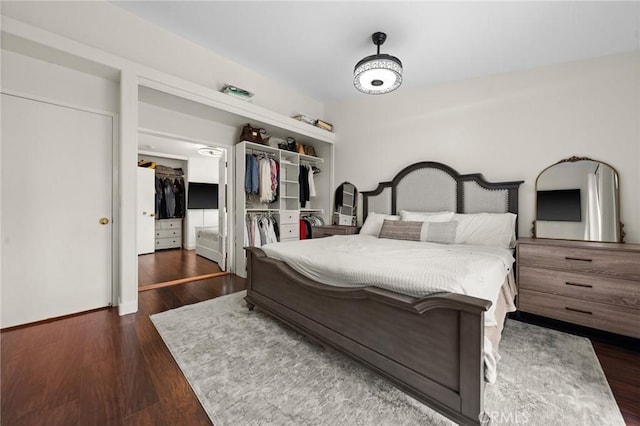 bedroom with dark hardwood / wood-style flooring and a closet