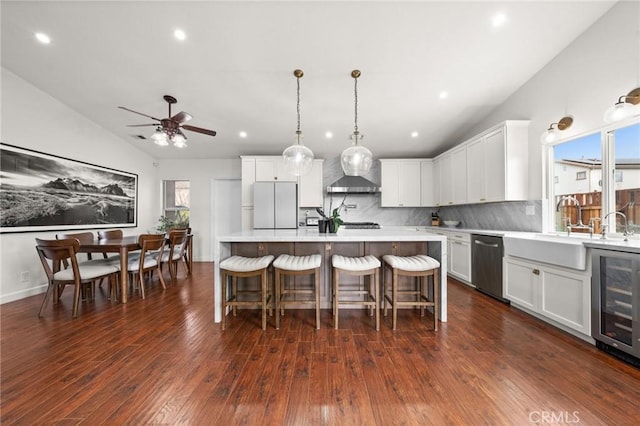 kitchen with white refrigerator, white cabinetry, a center island, and beverage cooler