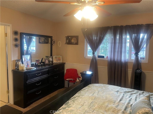 bedroom featuring ceiling fan and a textured ceiling