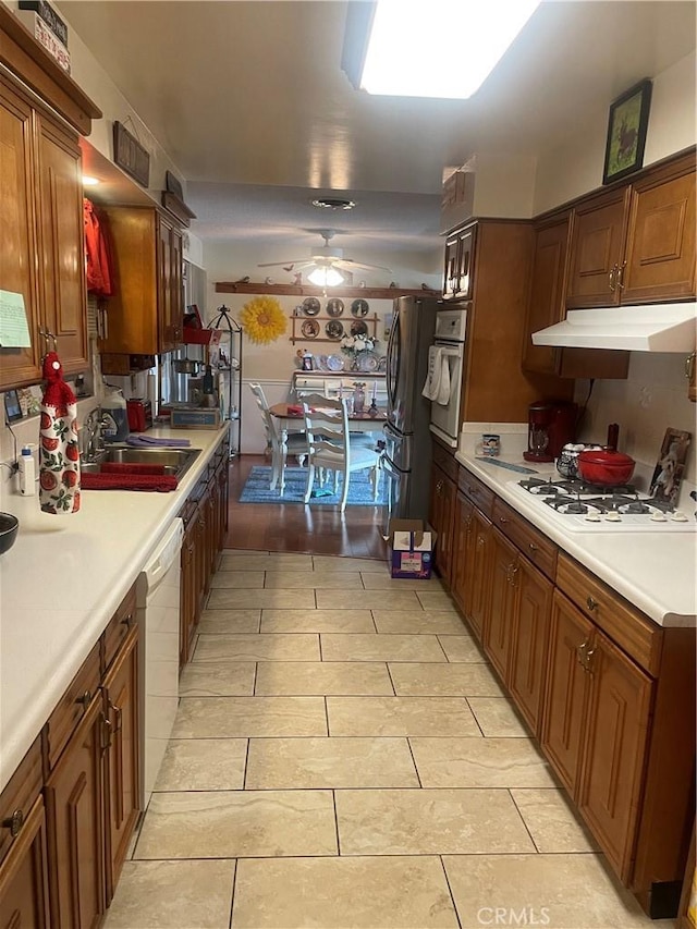 kitchen featuring ceiling fan, sink, and white appliances