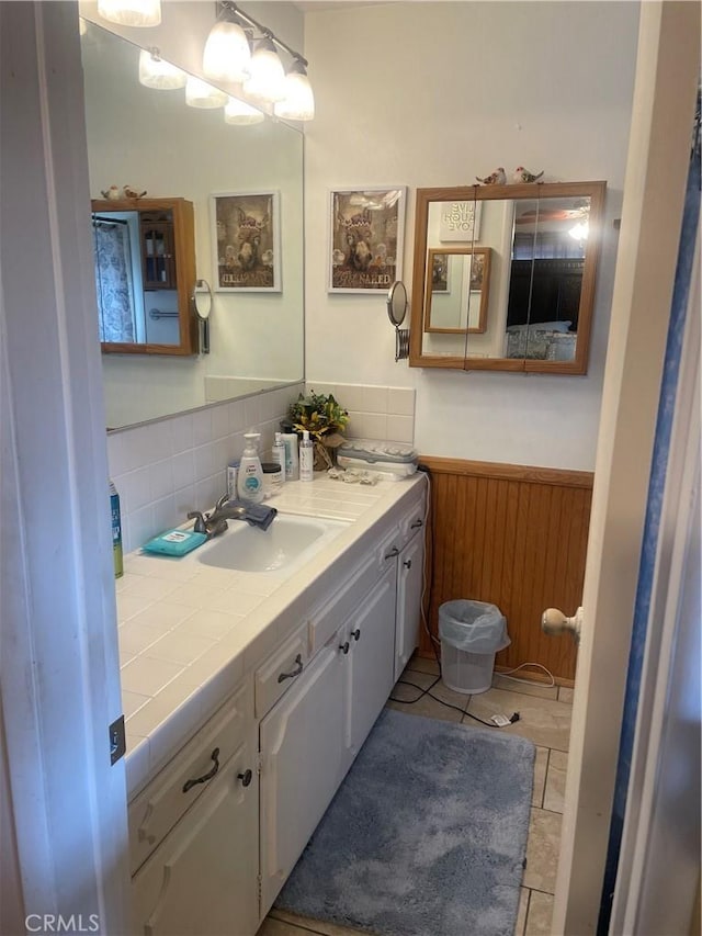 bathroom featuring vanity, backsplash, tile patterned flooring, and wooden walls