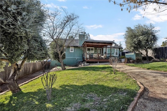 rear view of property with a wooden deck and a yard