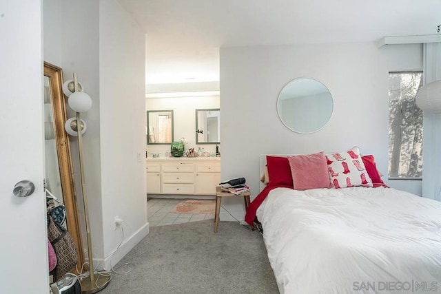 bedroom with connected bathroom and light colored carpet