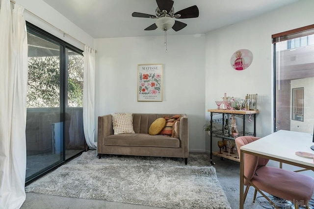 sitting room with ceiling fan and carpet flooring