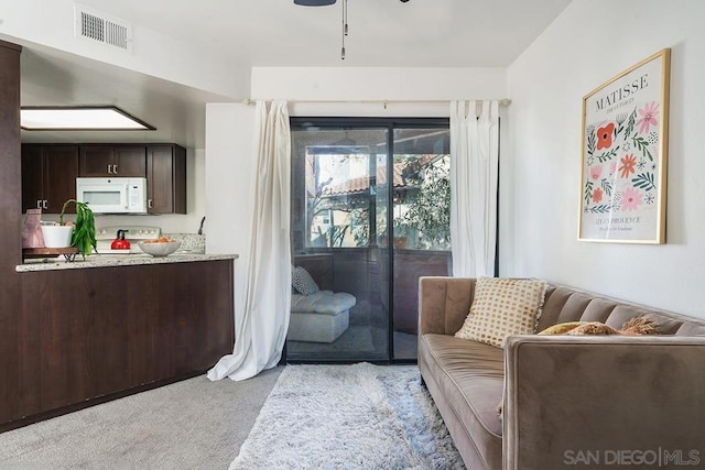 sitting room featuring light colored carpet and ceiling fan