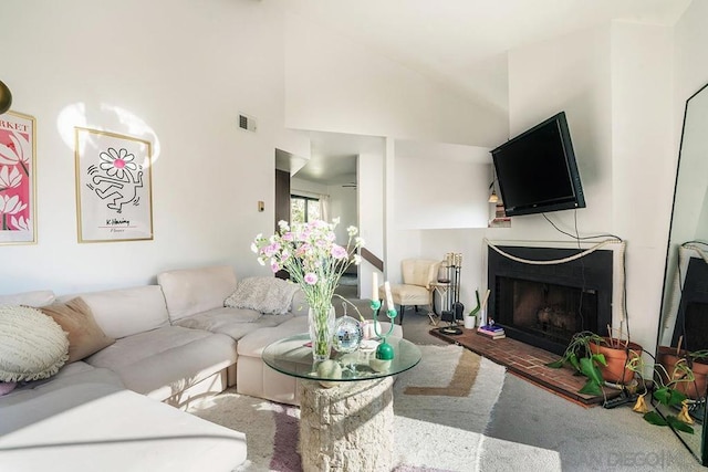 carpeted living room with high vaulted ceiling