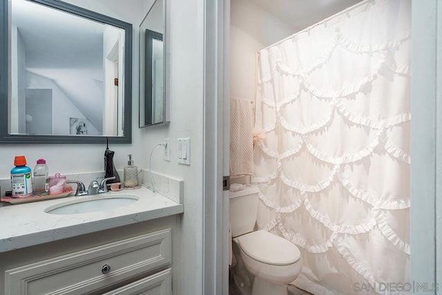 bathroom featuring vanity, curtained shower, and toilet