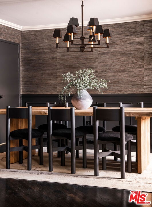 bar featuring dark brown cabinetry, ornamental molding, hardwood / wood-style floors, and an inviting chandelier