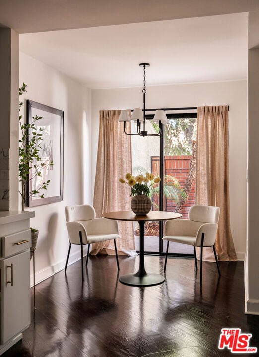 dining room with dark hardwood / wood-style floors and a notable chandelier