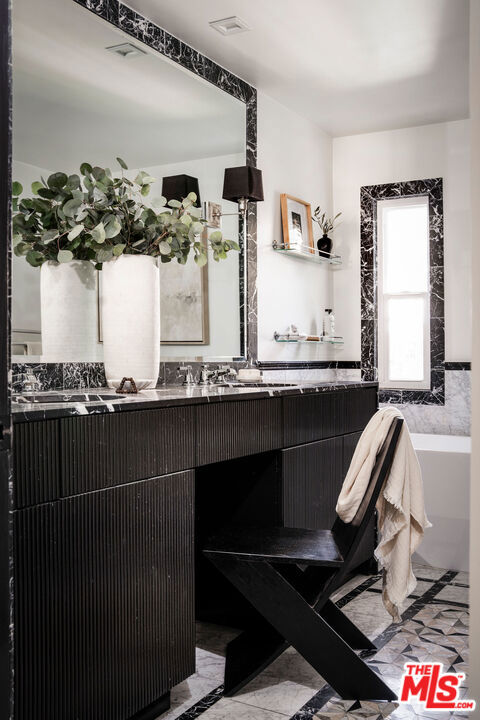 bathroom featuring vanity and a bath