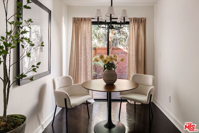 dining space with an inviting chandelier and dark hardwood / wood-style flooring