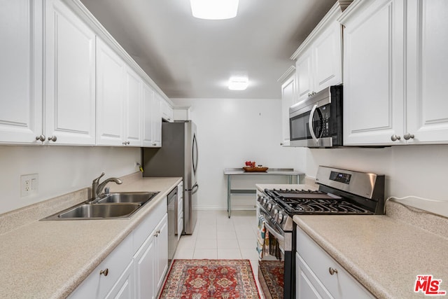 kitchen featuring sink, light tile patterned floors, white cabinets, and appliances with stainless steel finishes