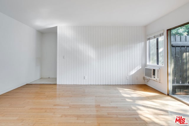 unfurnished room with cooling unit and light hardwood / wood-style floors