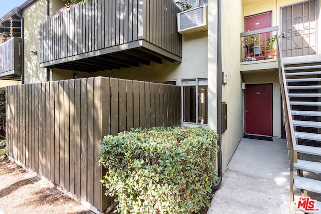 view of exterior entry with a balcony