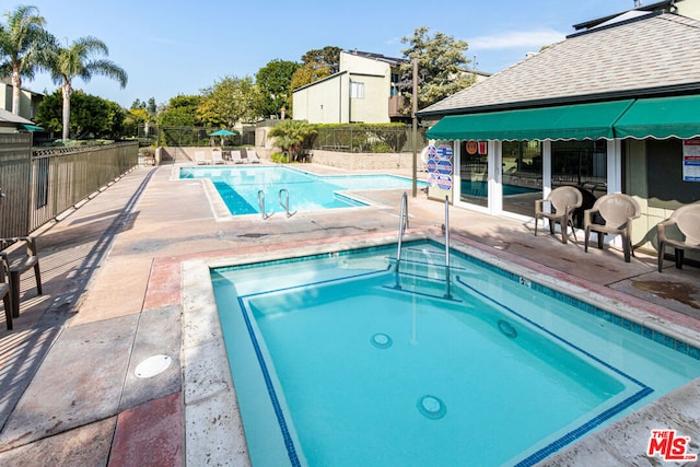 view of pool with a patio area and a hot tub