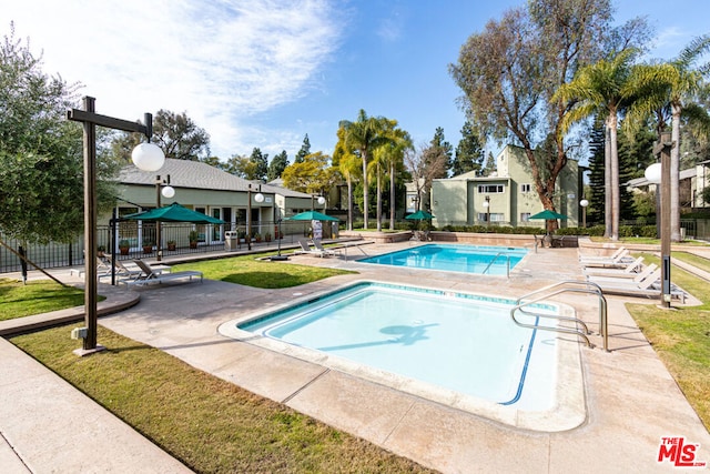 view of swimming pool with a patio area and a lawn