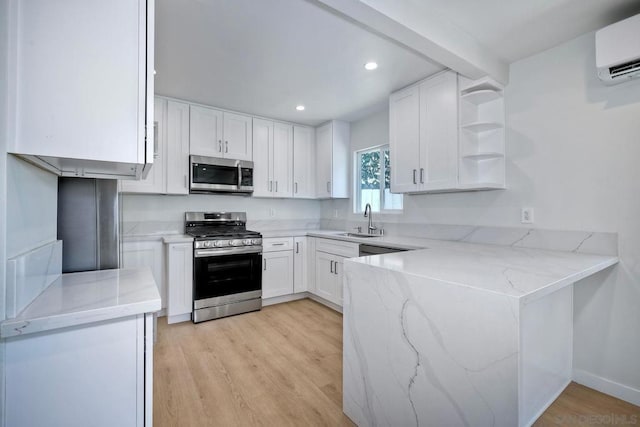 kitchen with light stone counters, sink, stainless steel appliances, and white cabinets