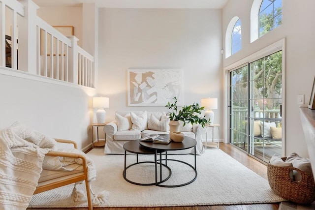 living room with a towering ceiling and wood-type flooring