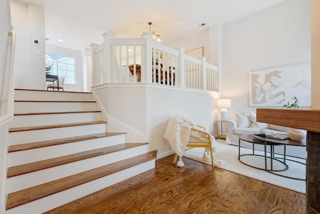 staircase featuring hardwood / wood-style flooring and a high ceiling