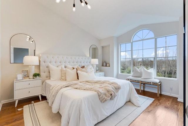 bedroom featuring vaulted ceiling and wood-type flooring