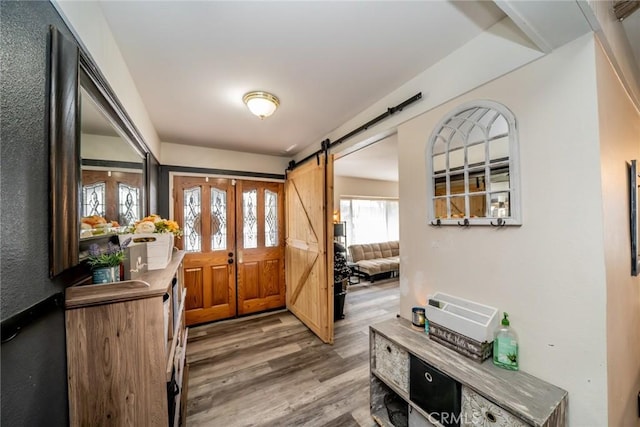 foyer entrance with wood-type flooring and a barn door