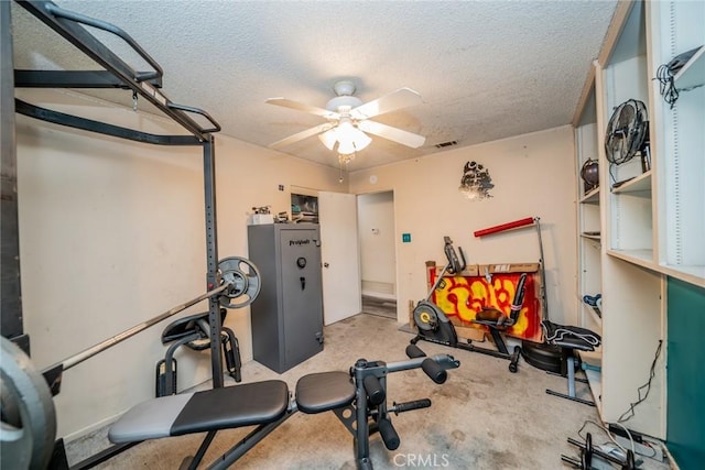 workout room with ceiling fan and a textured ceiling