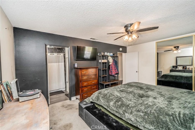 carpeted bedroom featuring ceiling fan and a textured ceiling